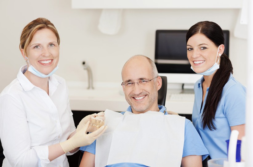 Dentista, higuienista y paciente posando para foto